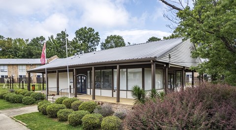 the front of a building with a porch and a flag